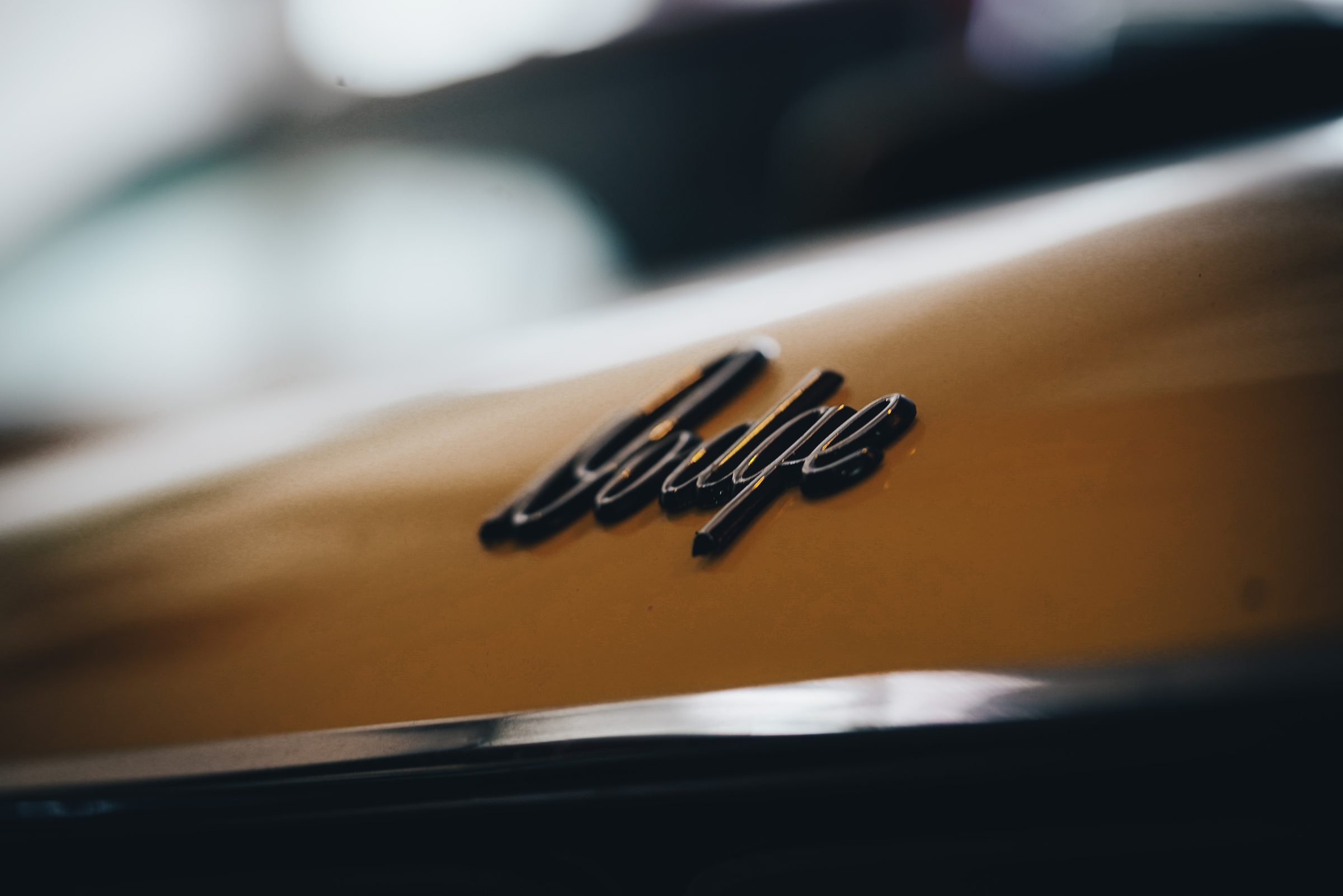 Dodge script badge on a classic gold car