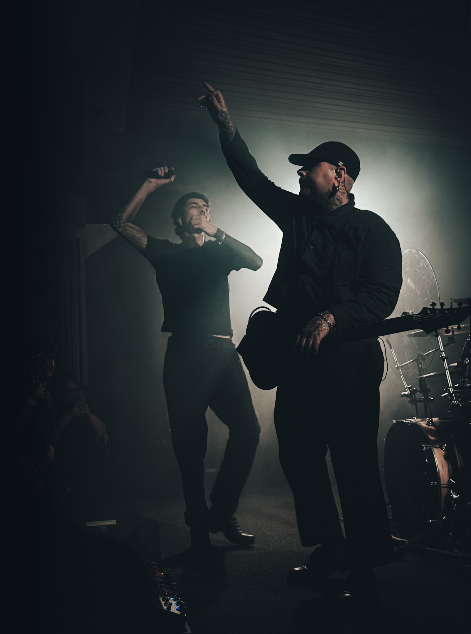 Two musicians on stage, one pointing to the crowd