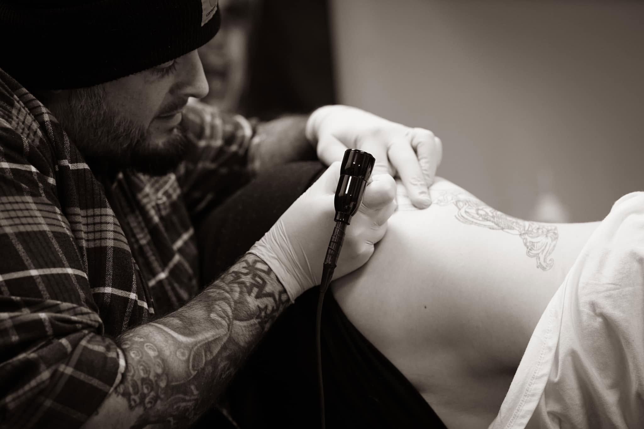 Tattoo artist at work, monochrome